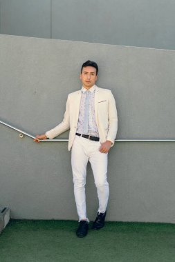 İki renkli kot pantolonlu, siyah beyaz kravatlı ve gözlüklü bir adam..