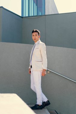 İki renkli kot pantolonlu, siyah beyaz kravatlı ve gözlüklü bir adam..