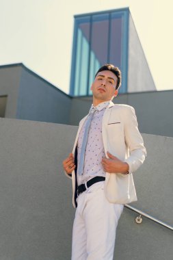 İki renkli kot pantolonlu, siyah beyaz kravatlı ve gözlüklü bir adam..