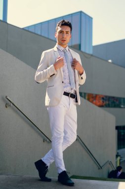 İki renkli kot pantolonlu, siyah beyaz kravatlı ve gözlüklü bir adam..