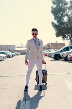 İki renkli kot pantolonlu, siyah beyaz kravatlı ve gözlüklü bir adam..