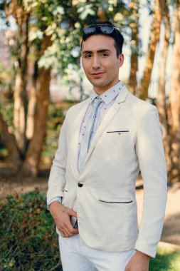 İki renkli kot pantolonlu, siyah beyaz kravatlı ve gözlüklü bir adam..