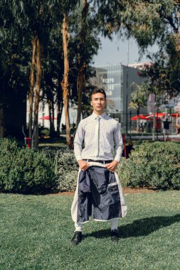 İki renkli kot pantolonlu, siyah beyaz kravatlı ve gözlüklü bir adam..