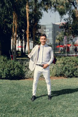 İki renkli kot pantolonlu, siyah beyaz kravatlı ve gözlüklü bir adam..