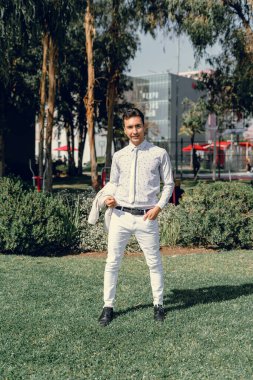 İki renkli kot pantolonlu, siyah beyaz kravatlı ve gözlüklü bir adam..