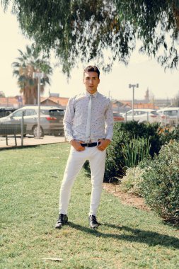 İki renkli kot pantolonlu, siyah beyaz kravatlı ve gözlüklü bir adam..