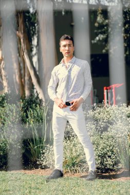 İki renkli kot pantolonlu, siyah beyaz kravatlı ve gözlüklü bir adam..