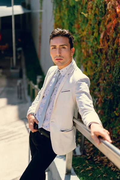 İki renkli kot pantolonlu, siyah beyaz kravatlı ve gözlüklü bir adam..