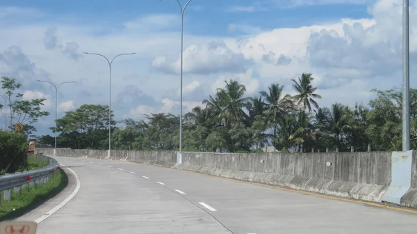 Katı beton yolun bulanık resmi berrak mavi gökyüzü ve biraz bulutlu.