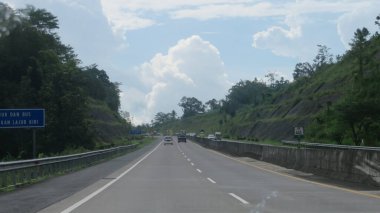 Katı beton yolun bulanık resmi berrak mavi gökyüzü ve biraz bulutlu.