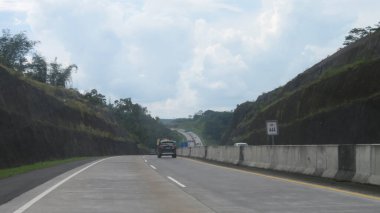 Katı beton yolun bulanık resmi berrak mavi gökyüzü ve biraz bulutlu.