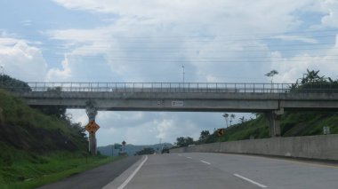 Katı beton yolun bulanık resmi berrak mavi gökyüzü ve biraz bulutlu.