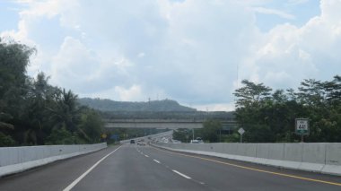 Katı beton yolun bulanık resmi berrak mavi gökyüzü ve biraz bulutlu.