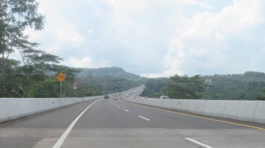 Katı beton yolun bulanık resmi berrak mavi gökyüzü ve biraz bulutlu.