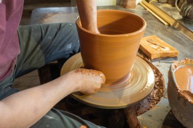 Bir çömlekçinin elleri, çemberin üzerinde toprak kavanozu yaratıyor..