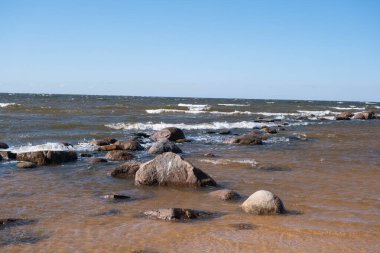 Baltık Denizi, Riga Körfezi. Deniz kenarındaki kayalar, ilkbaharın başlarında. Dalgalar kayaların üzerinden geçiyor..