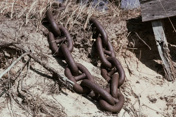 rusty tangled chains in a ball with thick links on the ground of a harbor - steampunk heavy wallpaper.