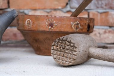 old wooden meat hammer with an edge ceramic bowl. Latvia. clipart