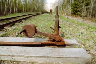 Eski paslı demir dar ölçü demiryolunun ok yuvarlak çevirisi.