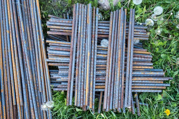 Metal fittings for reinforced concrete. Main construction materials. Background and rusty iron reinforcement rods. Red orange color of iron oxide on reinforcement bars.