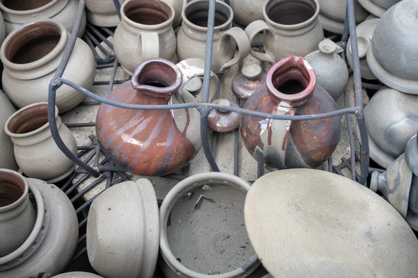 opening of a ceramic kiln, Unique handmade pots and dishes of clay getting black after firing and oxygen reducing process in wood fire kiln. Latvian national crafts