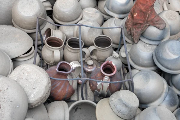 opening of a ceramic kiln, Unique handmade pots and dishes of clay getting black after firing and oxygen reducing process in wood fire kiln. Latvian national crafts