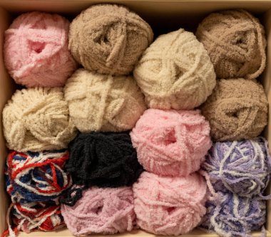 İplik toplarını kapatın. Gökkuşağı renkleri. Örgü örmek için iplik. İplik derileri. Örgü iğneleri, renkli iplikler. Örgü örmek, el yapımı kış kıyafetleri için örgü örmek.