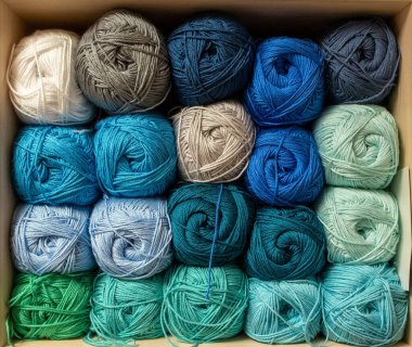 İplik toplarını kapatın. Gökkuşağı renkleri. Örgü örmek için iplik. İplik derileri. Örgü iğneleri, renkli iplikler. Örgü örmek, el yapımı kış kıyafetleri için örgü örmek.