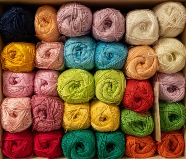 İplik toplarını kapatın. Gökkuşağı renkleri. Örgü örmek için iplik. İplik derileri. Örgü iğneleri, renkli iplikler. Örgü örmek, el yapımı kış kıyafetleri için örgü örmek.