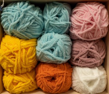 İplik toplarını kapatın. Gökkuşağı renkleri. Örgü örmek için iplik. İplik derileri. Örgü iğneleri, renkli iplikler. Örgü örmek, el yapımı kış kıyafetleri için örgü örmek.