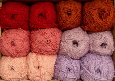 İplik toplarını kapatın. Gökkuşağı renkleri. Örgü örmek için iplik. İplik derileri. Örgü iğneleri, renkli iplikler. Örgü örmek, el yapımı kış kıyafetleri için örgü örmek.