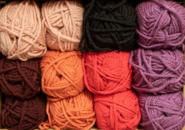 İplik toplarını kapatın. Gökkuşağı renkleri. Örgü örmek için iplik. İplik derileri. Örgü iğneleri, renkli iplikler. Örgü örmek, el yapımı kış kıyafetleri için örgü örmek.