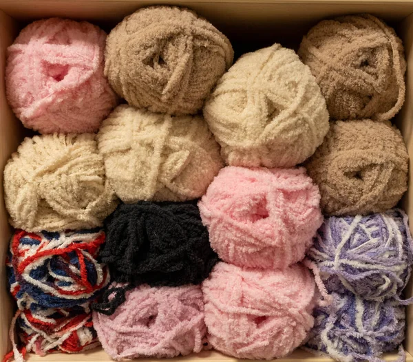 İplik toplarını kapatın. Gökkuşağı renkleri. Örgü örmek için iplik. İplik derileri. Örgü iğneleri, renkli iplikler. Örgü örmek, el yapımı kış kıyafetleri için örgü örmek.