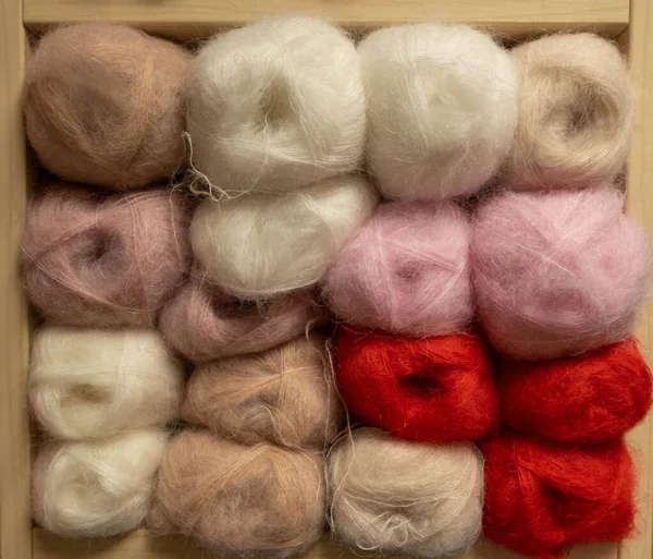 İplik toplarını kapatın. Gökkuşağı renkleri. Örgü örmek için iplik. İplik derileri. Örgü iğneleri, renkli iplikler. Örgü örmek, el yapımı kış kıyafetleri için örgü örmek..