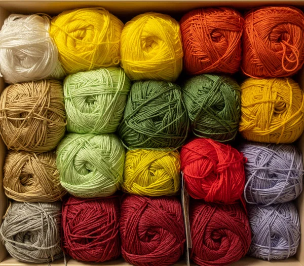 İplik toplarını kapatın. Gökkuşağı renkleri. Örgü örmek için iplik. İplik derileri. Örgü iğneleri, renkli iplikler. Örgü örmek, el yapımı kış kıyafetleri için örgü örmek.