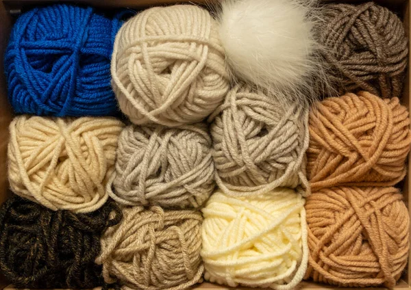 İplik toplarını kapatın. Gökkuşağı renkleri. Örgü örmek için iplik. İplik derileri. Örgü iğneleri, renkli iplikler. Örgü örmek, el yapımı kış kıyafetleri için örgü örmek.