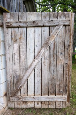 Detail of a open wooden door with big wooden lock in an old shack.