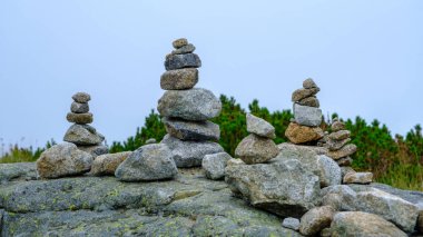 Many stone statues, pyramids are piled on the big rock.