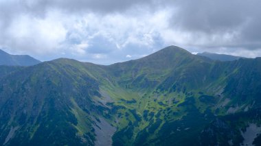 low hanging storm clouds and fog in the mountains on a summer day. blue haze in mountain valleys
