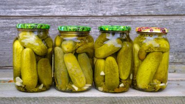 Salatalık turşulu cam kavanozlar. Çeşitli sebzelerle dolu kavanozlar. Kırsal bir kompozisyonda konserve yiyecek kavramı.