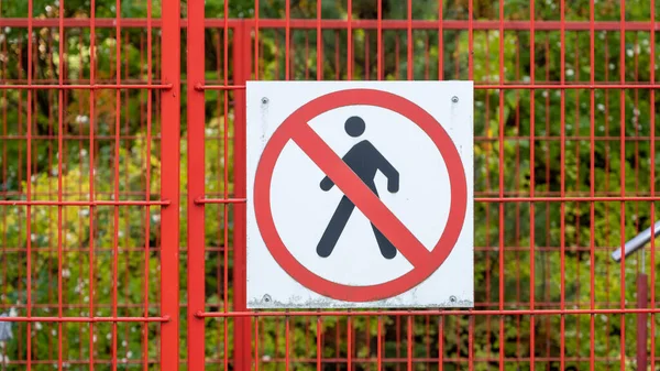 Closed access door to the construction site of a building, with a no-entry sign.