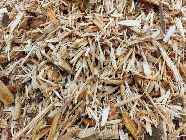 Small pile of wood chips background, top view. Waste from the woodworking industry, fuel and raw materials for heating solid fuel industrial boilers on wood chips.