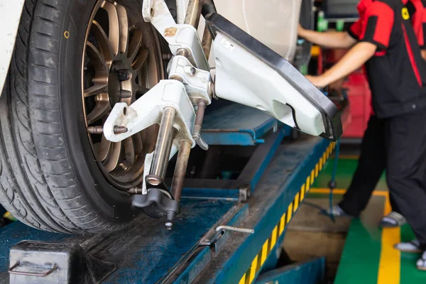 Servis atölyesindeki beyaz araba tekerleği testini kapattım. Bakım ve onarım otomobil taşımacılığı kavramı.