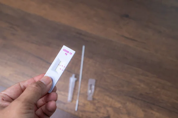 Covid-19 Tarım testinin el ele tutuşma kitleri veya fotokopi alanı olan ahşap arka planda görülen ATK, Corona virüsü 2019 salgınının kontrolü konsepti.