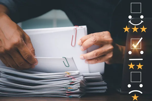 Satisfaction and customer service survey concept, business man's hand analyzing documents papers questionnaire and combining the satisfaction score, giving satisfaction rating with indifferent icon.