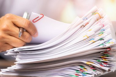 Beyaz gömlekli bir adamın yakın plan resimleri. Grup raporlarında sözleşme sözleşmesi belgeleri aranıyor. Rapor kağıtları açık ışık, iş, hukuk hukuku ve eğitim konseptiyle renklendirilmiş..