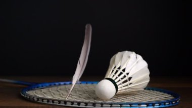 Siyah arka planda badminton topları olan raketin üzerine düşen tüylerin yavaş çekim görüntüsü, Shuttlecock spor etkinliği konsepti.