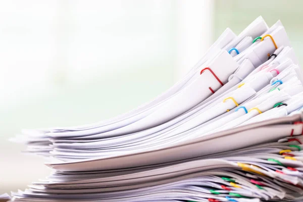 Close-up of Stack of Group report papers Document clipped in color clips, business, and education concept.