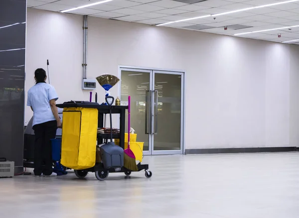 Janitorial car cleaning equipment with warning signs cleaning in process the floor in the building and the maid is working.