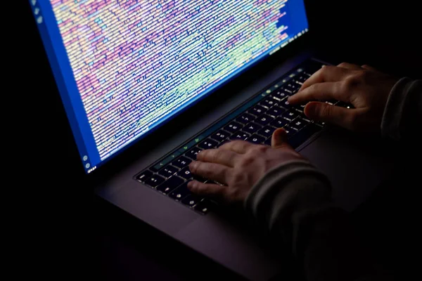 Yakın plan kadın yazılım geliştirici eller. Geceleri karanlıkta çalışan programcı.